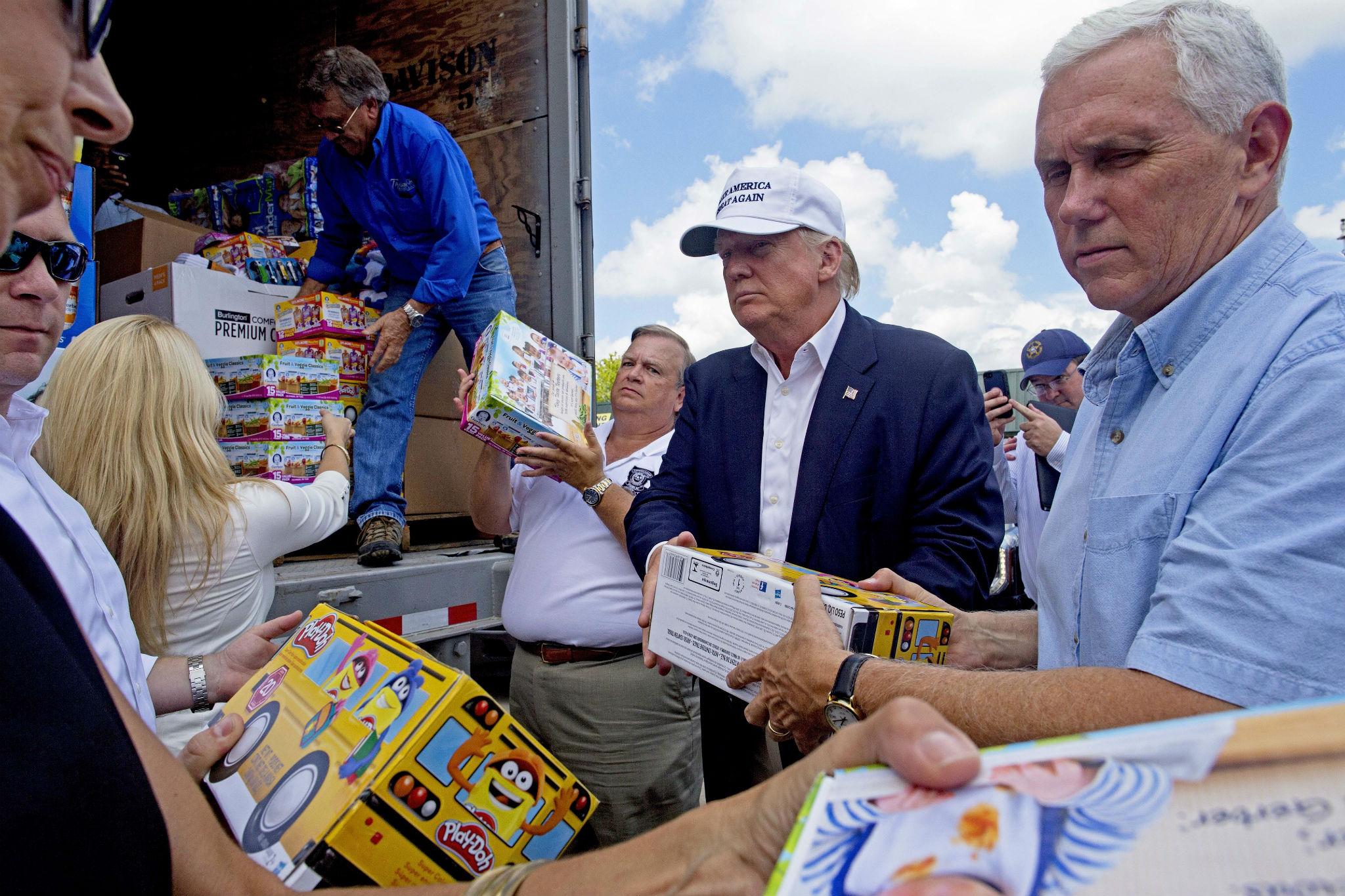 Republican presidential nominee Donald Trump and his running mate Mike Pence hand out supplies to flood-affected Louisiana residents on Friday, 19 August (AP)