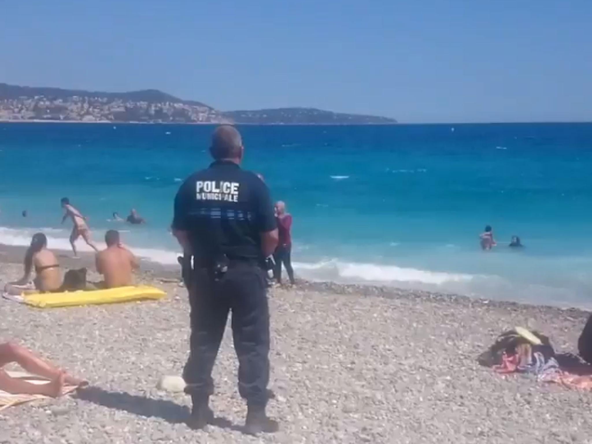 Police on the beach in Nice confront a woman in a burkini