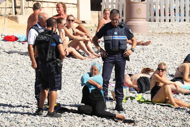 A woman on Nice beach is forced to remove her clothing by French police