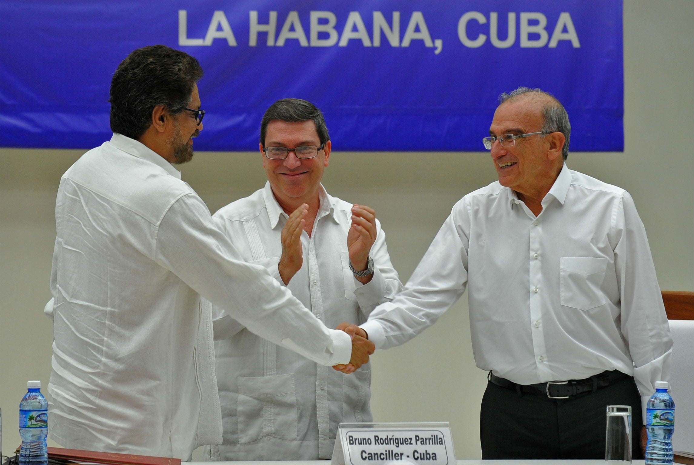 Colombia's Humberto de la Calle (right) and the FARC Commander Ivan Marquez (left) shake hands upon the signing of the agreement at the Convention Palace in Havana