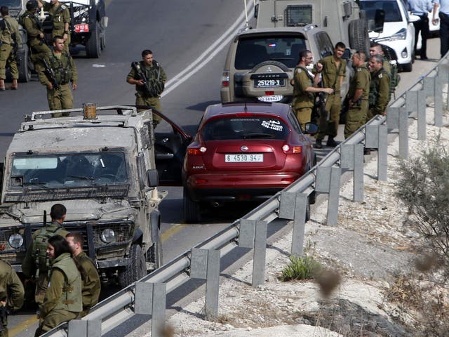 Israeli soldiers next to a car in which Palestinian man was shot dead after stabbing a soldier on 24 August, near Nablus in the West Bank.