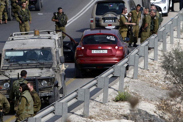 Israeli soldiers next to a car in which Palestinian man was shot dead after stabbing a soldier on 24 August, near Nablus in the West Bank.