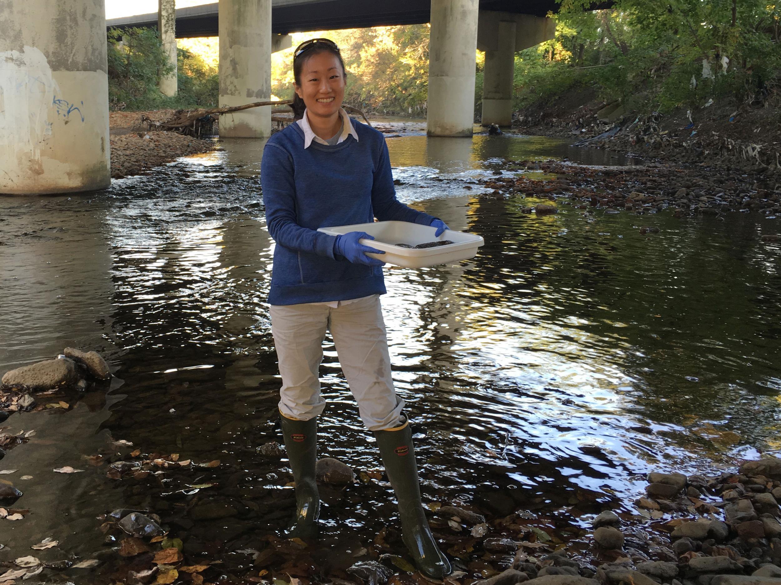 Sylvia Lee samples Gwynns Falls at Carroll Park, Baltimore, where water is polluted with amphetamines, also known as speed