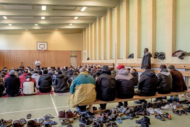 Asylum seekers pray in the gym of Sweden's largest temporary camp for migrants, in a former psychiatric hospital