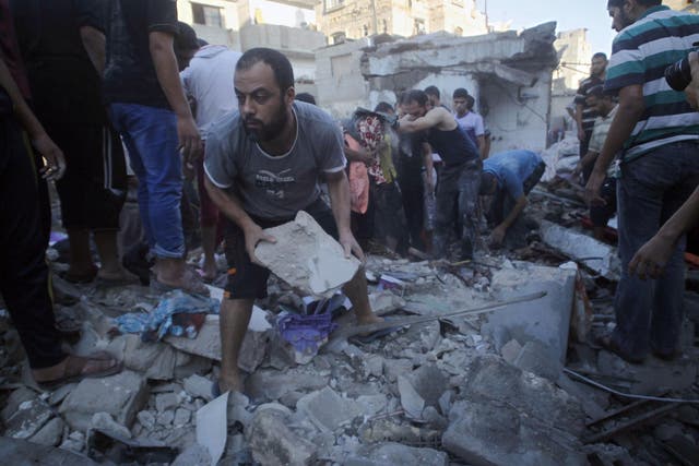 In this file photo Palestinians search through the rubble for survivors following an Israeli air strike