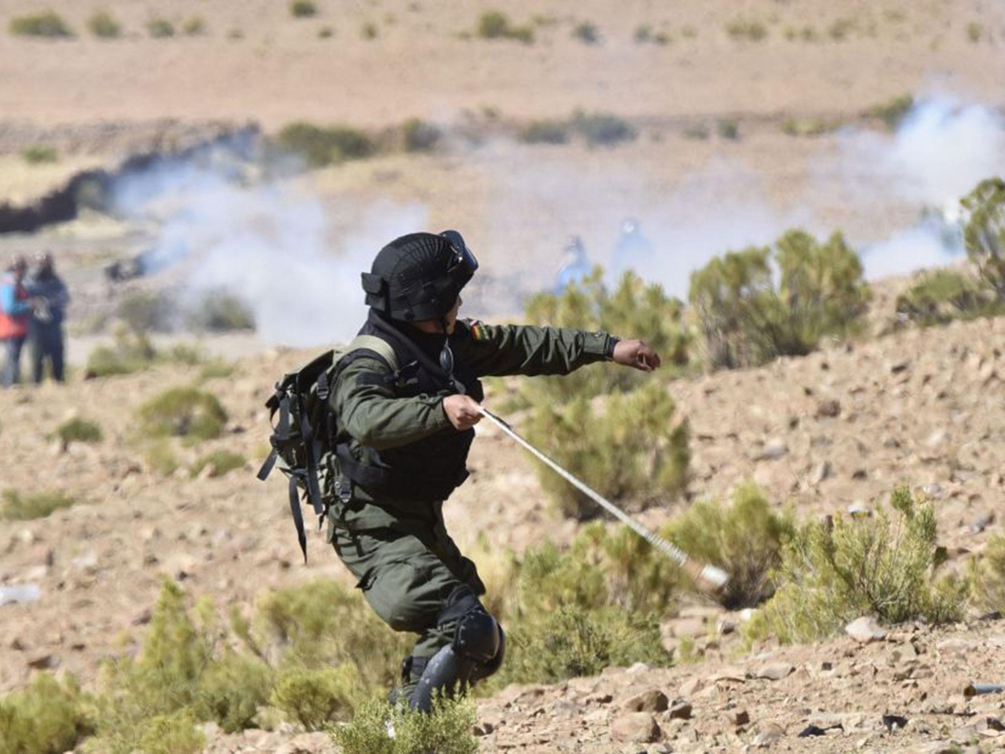 A riot policeman throws tear gas during clashes with the miners (AIZAR RALDESAIZAR RALDES/AFP/Getty)