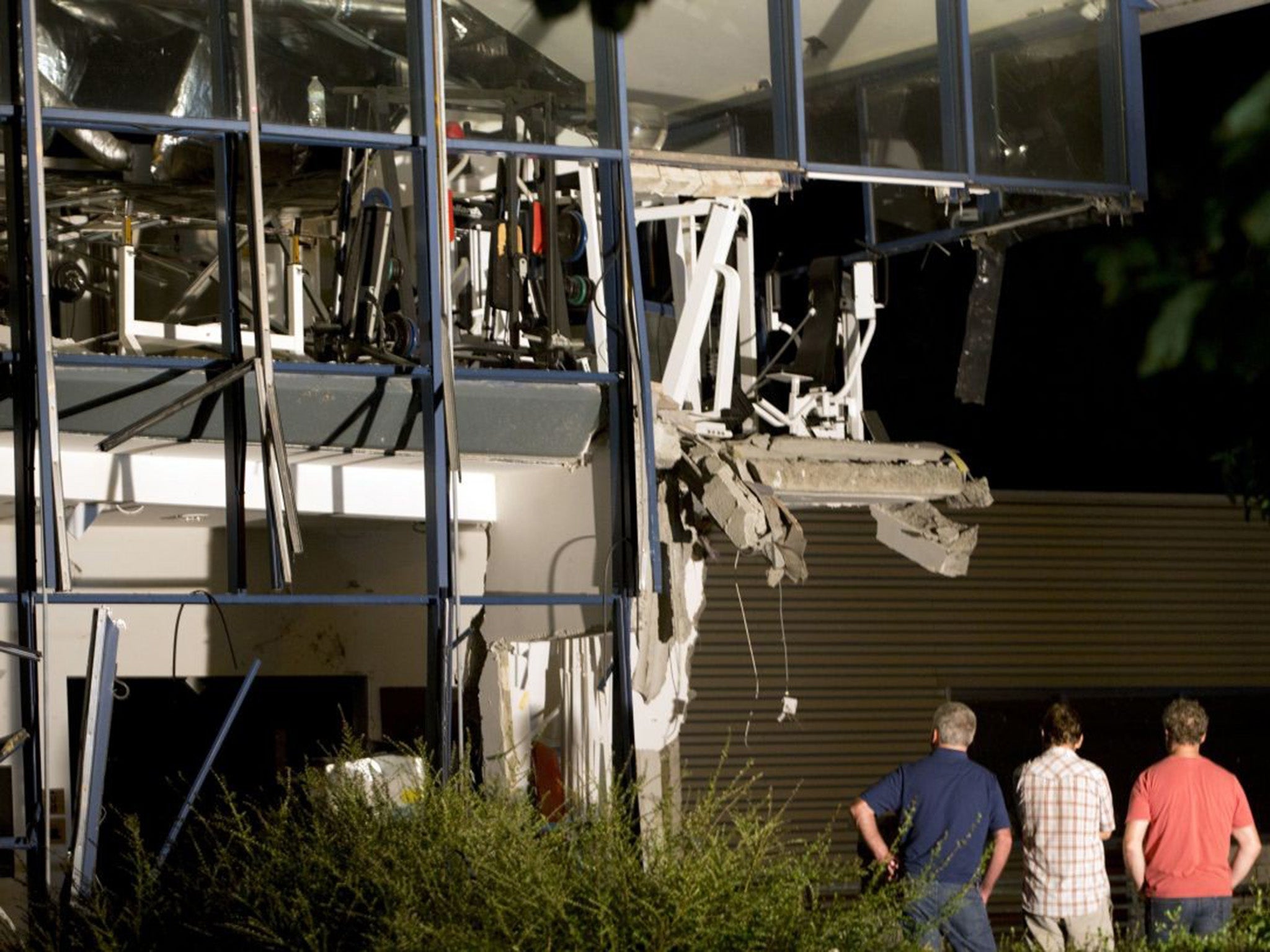 Police inspectors survey the damage to the sports complex in Chimay, Belgium after the explosion on Thursday night