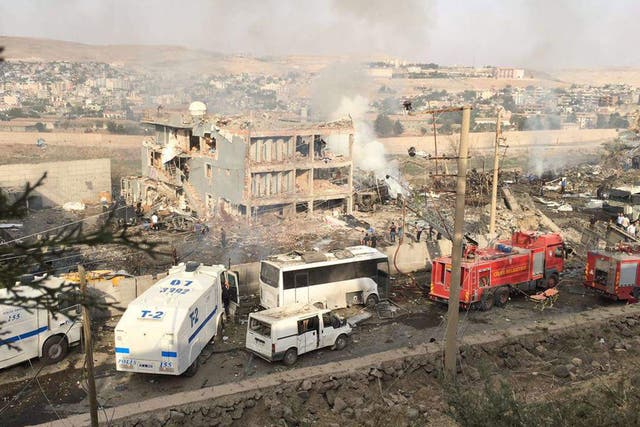 Turkish police and firefighters are parked near a police headquarters after a bombing in Cizre on 26 August 2016