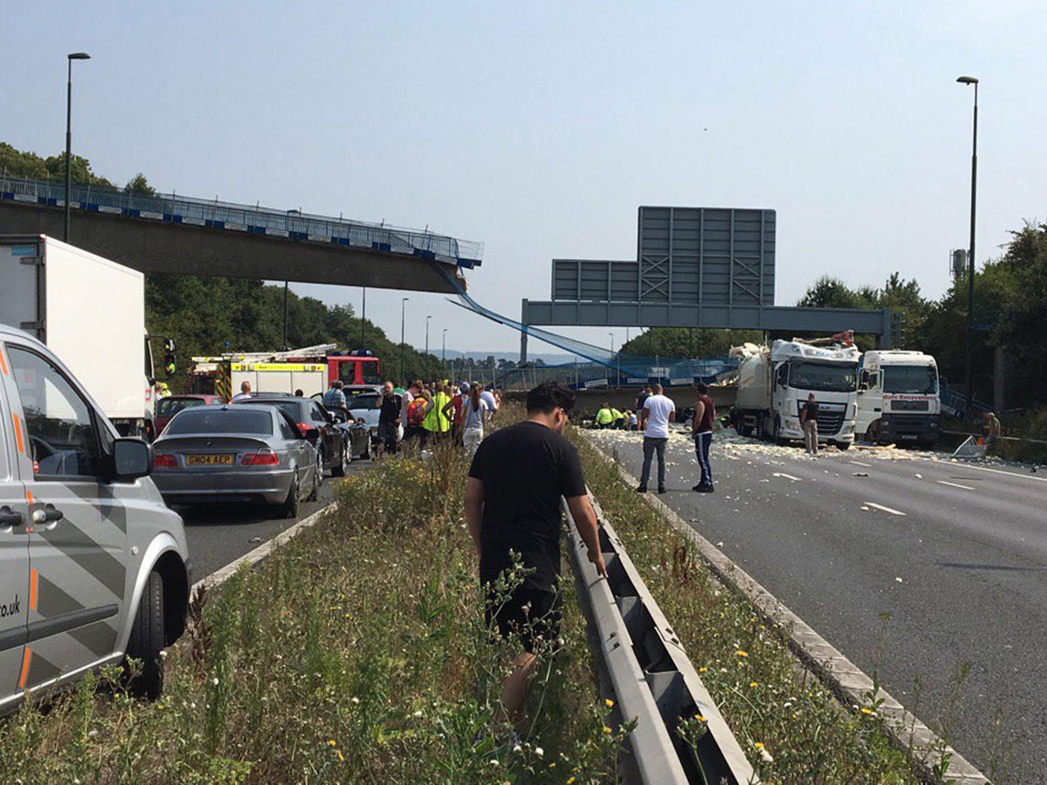 Emergency services at the scene where a footbridge collapsed on the M20 on 27 August