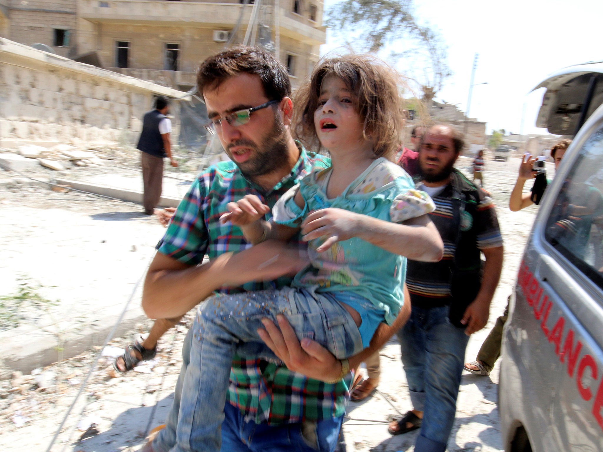 A man carries a girl that survived bombing on the rebel held Bab al-Nayrab neighborhood of Aleppo on 27 August