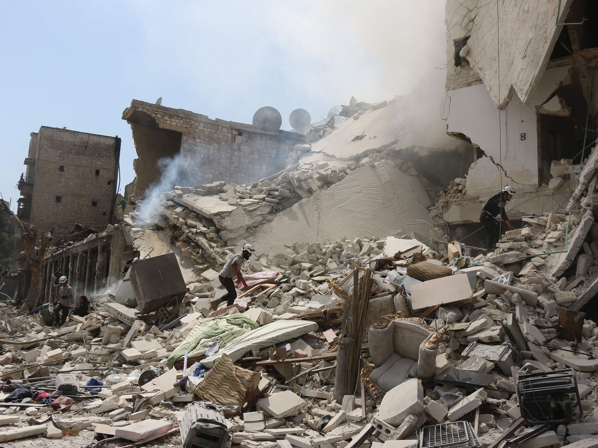 Rescue workers search for victims through the rubble of a building destroyed during a reported barrel bomb attack in a rebel-held neighbourhood in eastern Aleppo on August 27, 2016