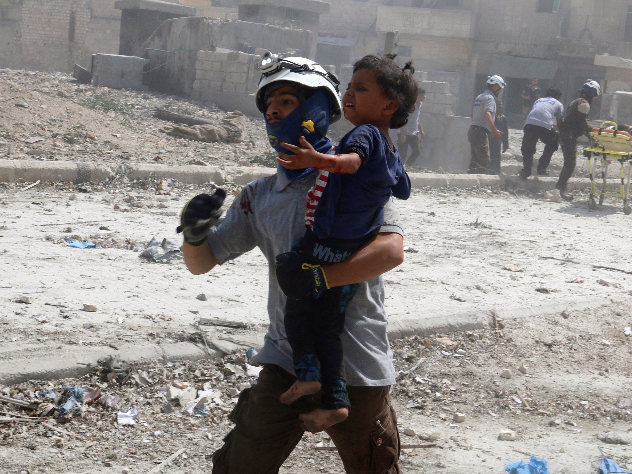 A man carries an injured child after the bombing in the rebel held Bab al-Nayrab neighborhood of Aleppo