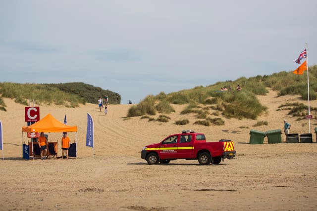 Coastal officers drive towards a beach patrol tent on Camber Sands
