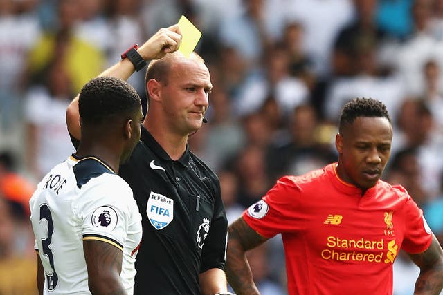 Madley, the match referee, awards Tottenham's Danny Rose a yellow card