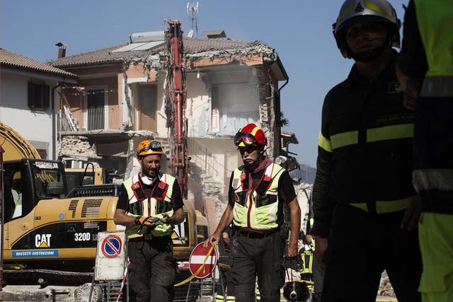 Fire fighters prepare for a controlled demolition in the centre of Amatrice, Italy, yesterday