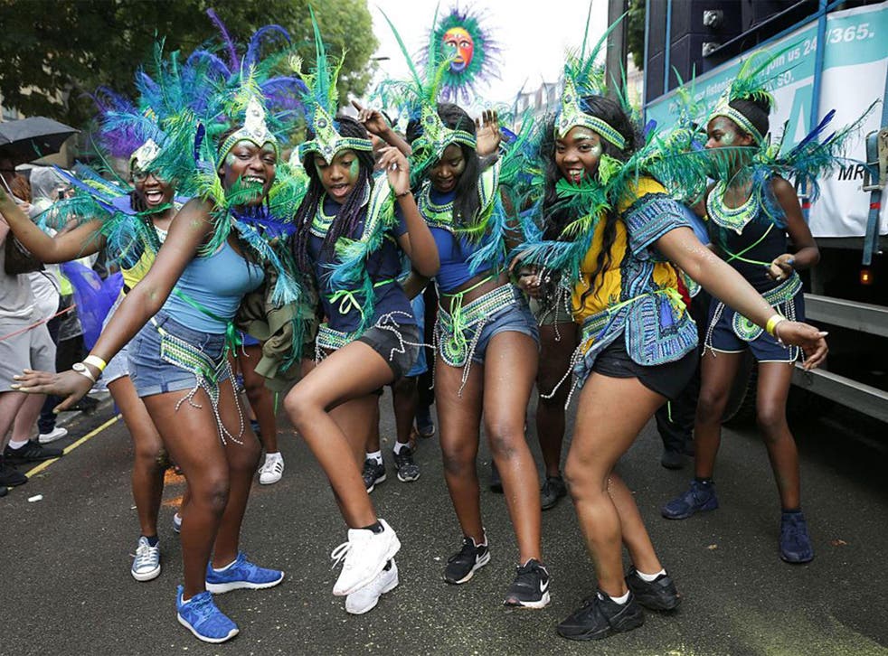 Performers in costume pose on the first day of the Notting Hill Carnival in west London