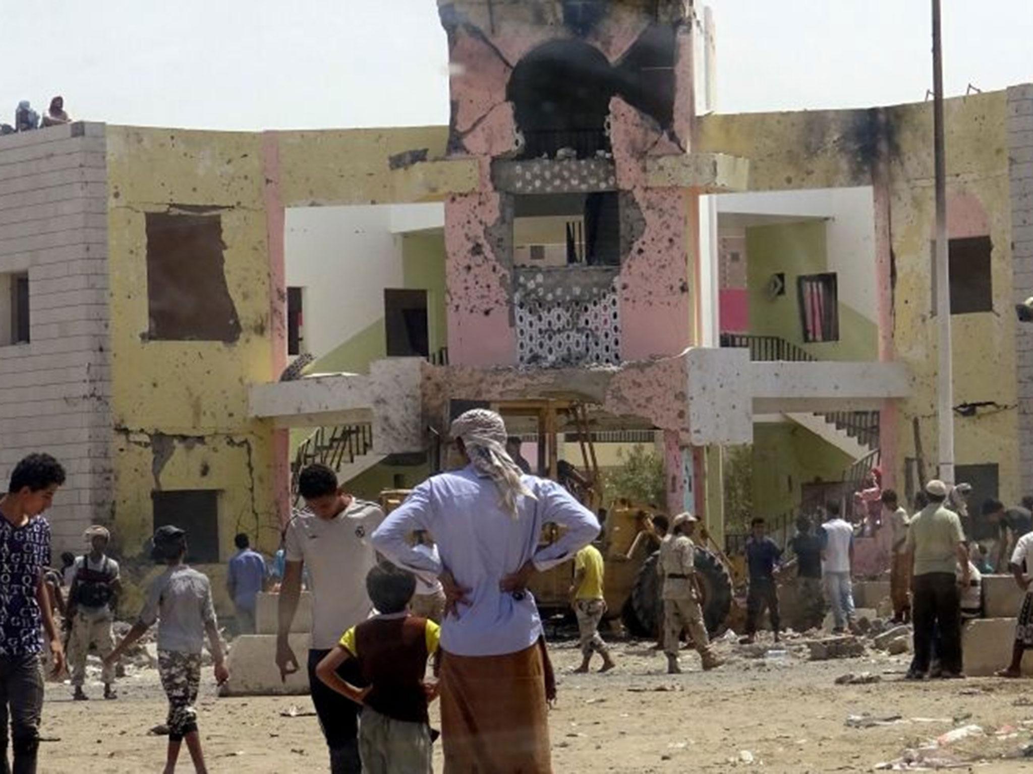 People gather at the scene following an attack by a suicide bomber who drove a car laden with explosives into a compound run by local militias in the port city of Aden, Yemen, 29 August, 2016.