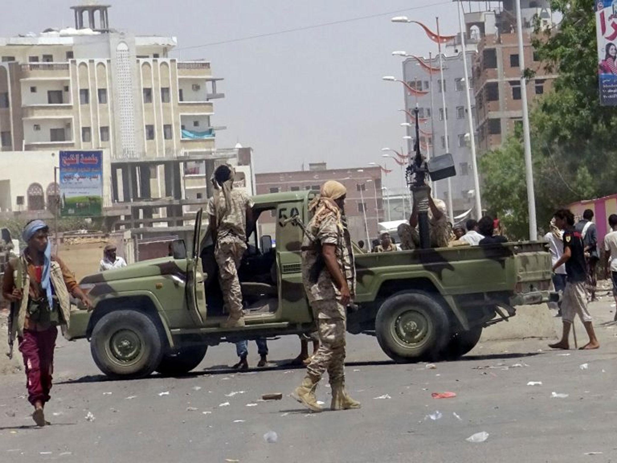 Soldiers and people gather at the site of the attack by a suicide bomber who drove a car laden with explosives into a compound run by local militias