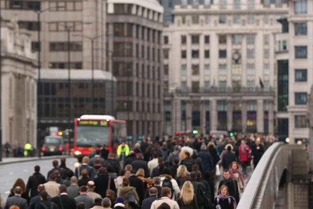 City workers cross London Bridge as they commute to work