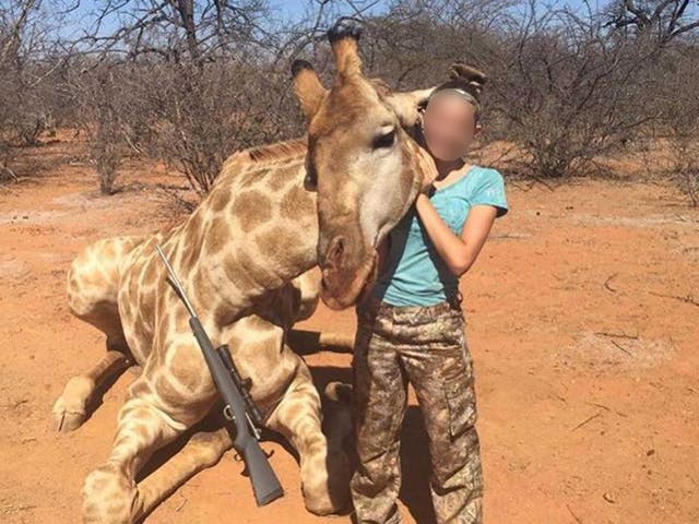 12-year-old Aryanna Gourdin posing with a dead giraffe