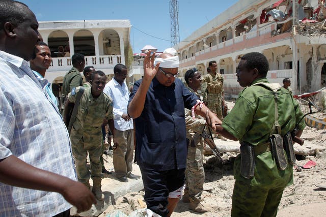 A soldier helps Somali politician Abdalla Bos Ahmed after he was injured by a blast near the presidential palace in Mogadishu yesterday