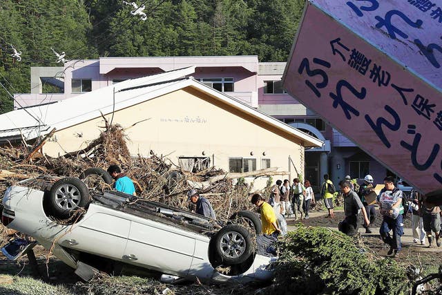 A car lays upside down near a nursing home where police discovered nine bodies, in Iwaizumi town, Iwate prefecture, northern Japan, Wednesday, Aug. 31, 2016, after Typhoon Lionrock dumped heavy rains.