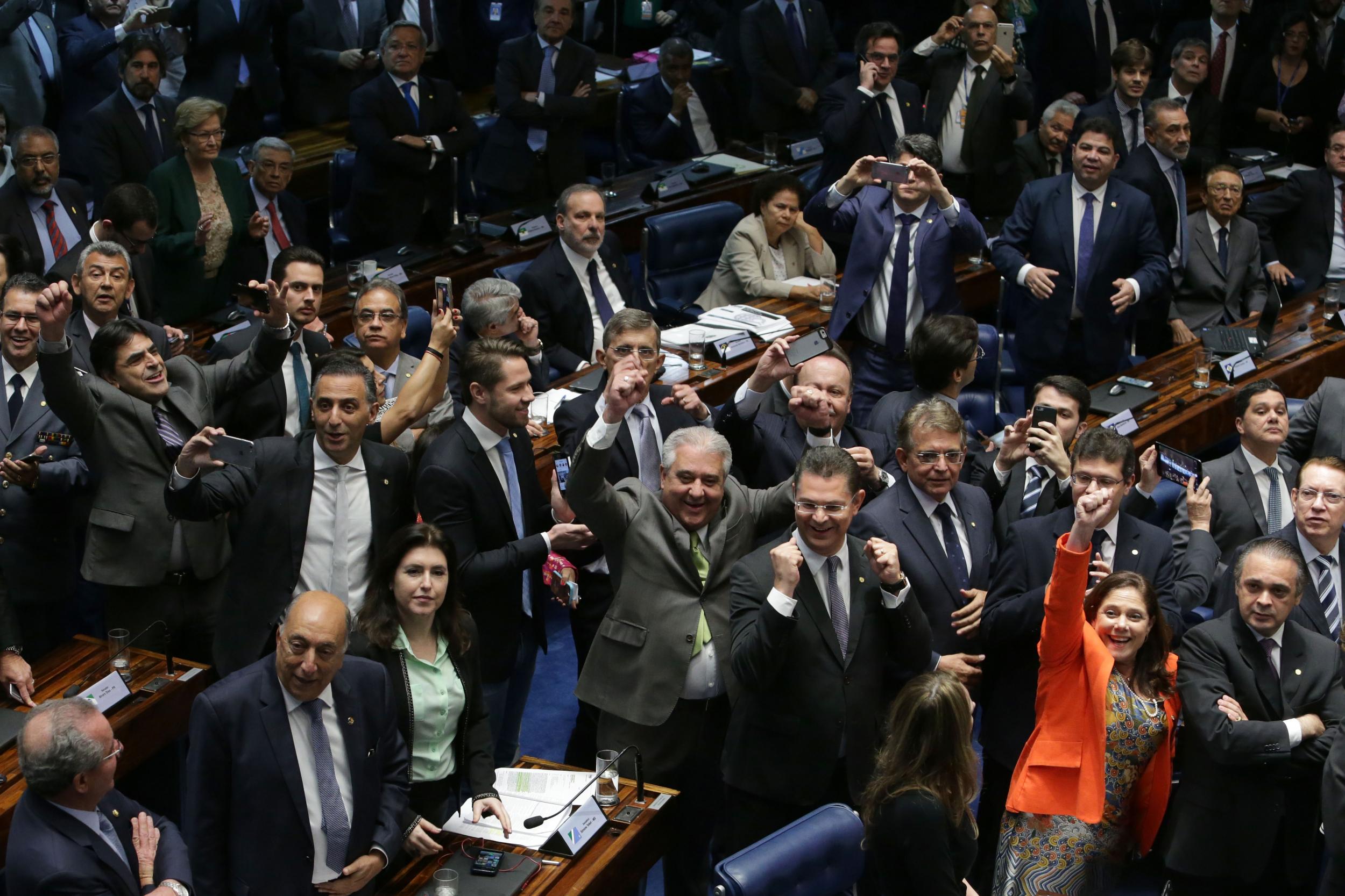 Brazilian senators celebrate after voting to permanently remove Ms Rousseff from office