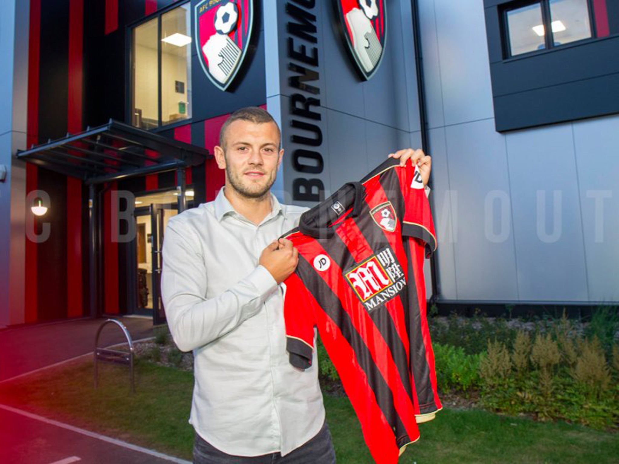 Wilshere poses with a Bournemouth shirt outside the Vitality Stadium