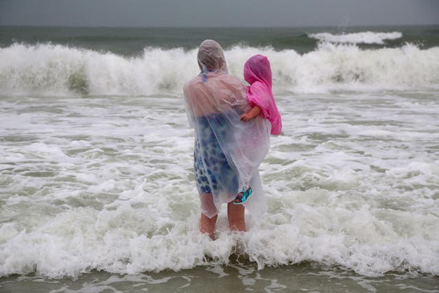 Lisa Bolton holds her three-year-old daughter Lois, both of Manchester, England, during a visit to Clearwater Beach, Florida as a storm closes in