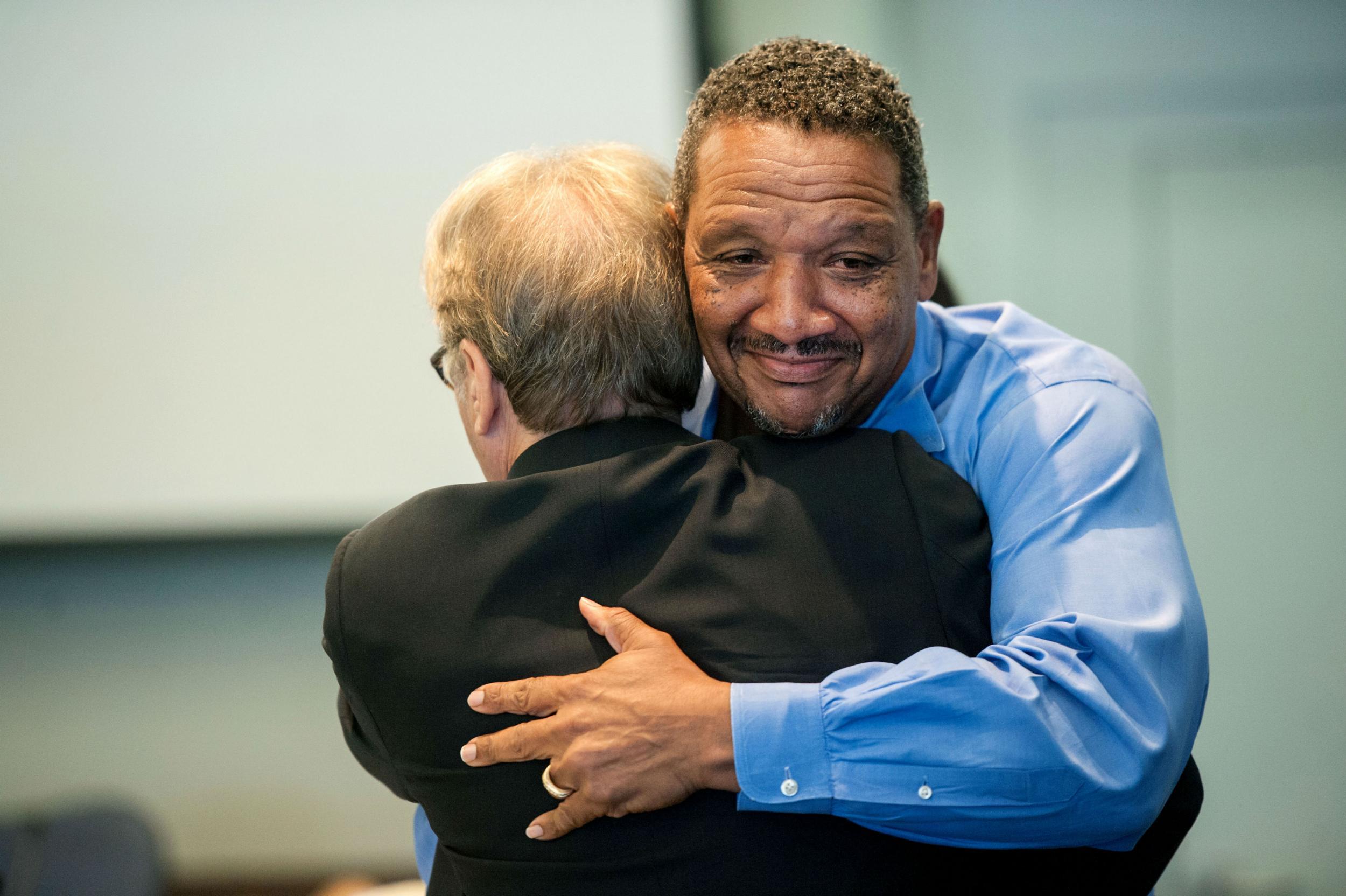 Darryl Howard hugs Barry Scheck of the Innocence Project after the ruling
