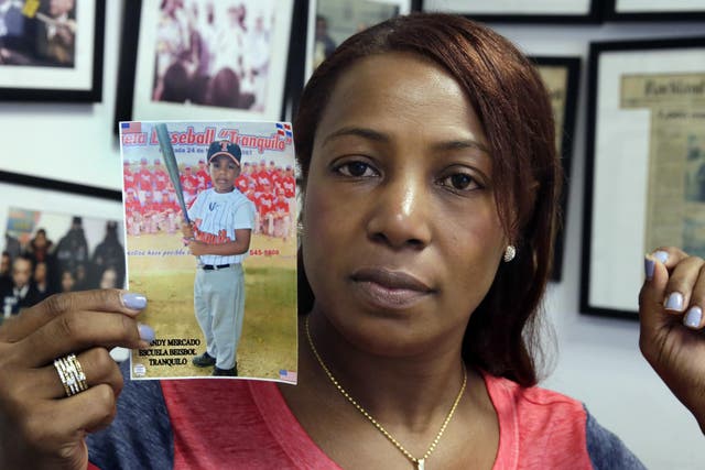 Maribel Martinez with a photo of her 5-year-old son Andy at her lawyer's office in New York