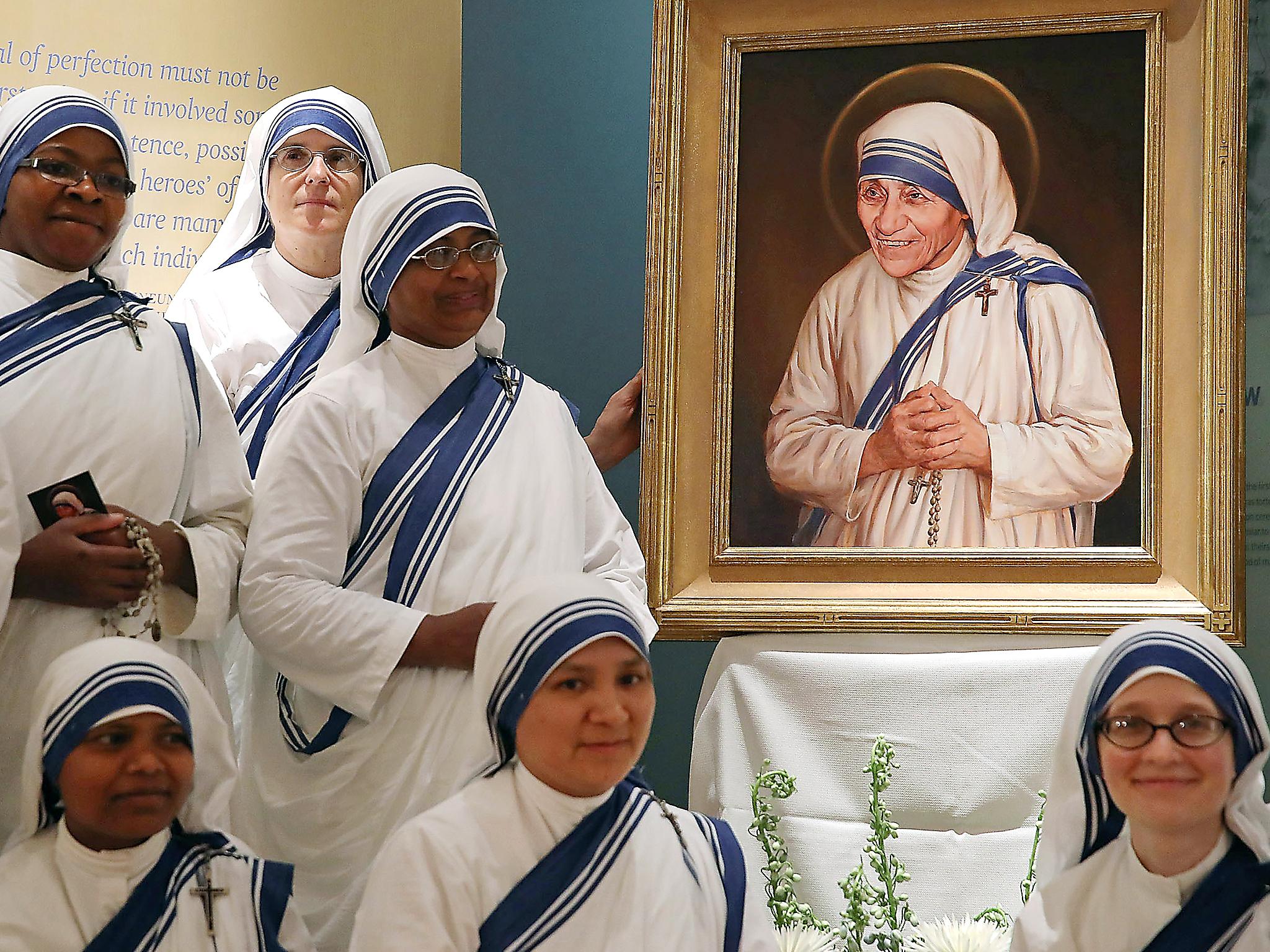 Sisters of the Missionaries of Charity, stand before the canonisation portrait of Mother Teresa at The Saint John Paul II National Shrine, Washington (Getty)