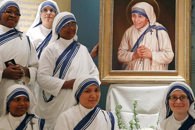 Sisters of the Missionaries of Charity, stand before the canonisation portrait of Mother Teresa at The Saint John Paul II National Shrine, Washington (Getty)