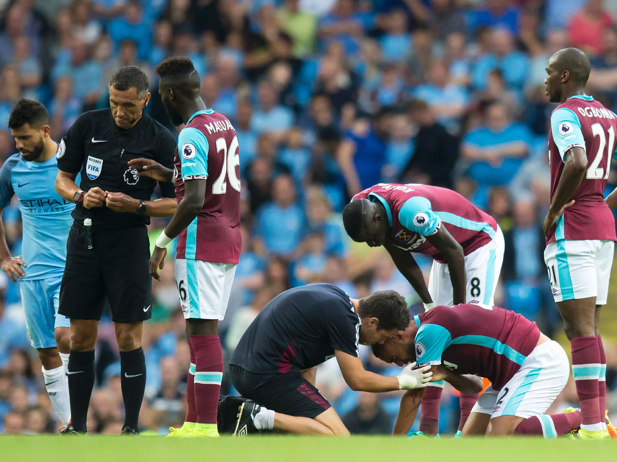 Winston Reid receives treatment after his clash with Sergio Aguero during Sunday's game