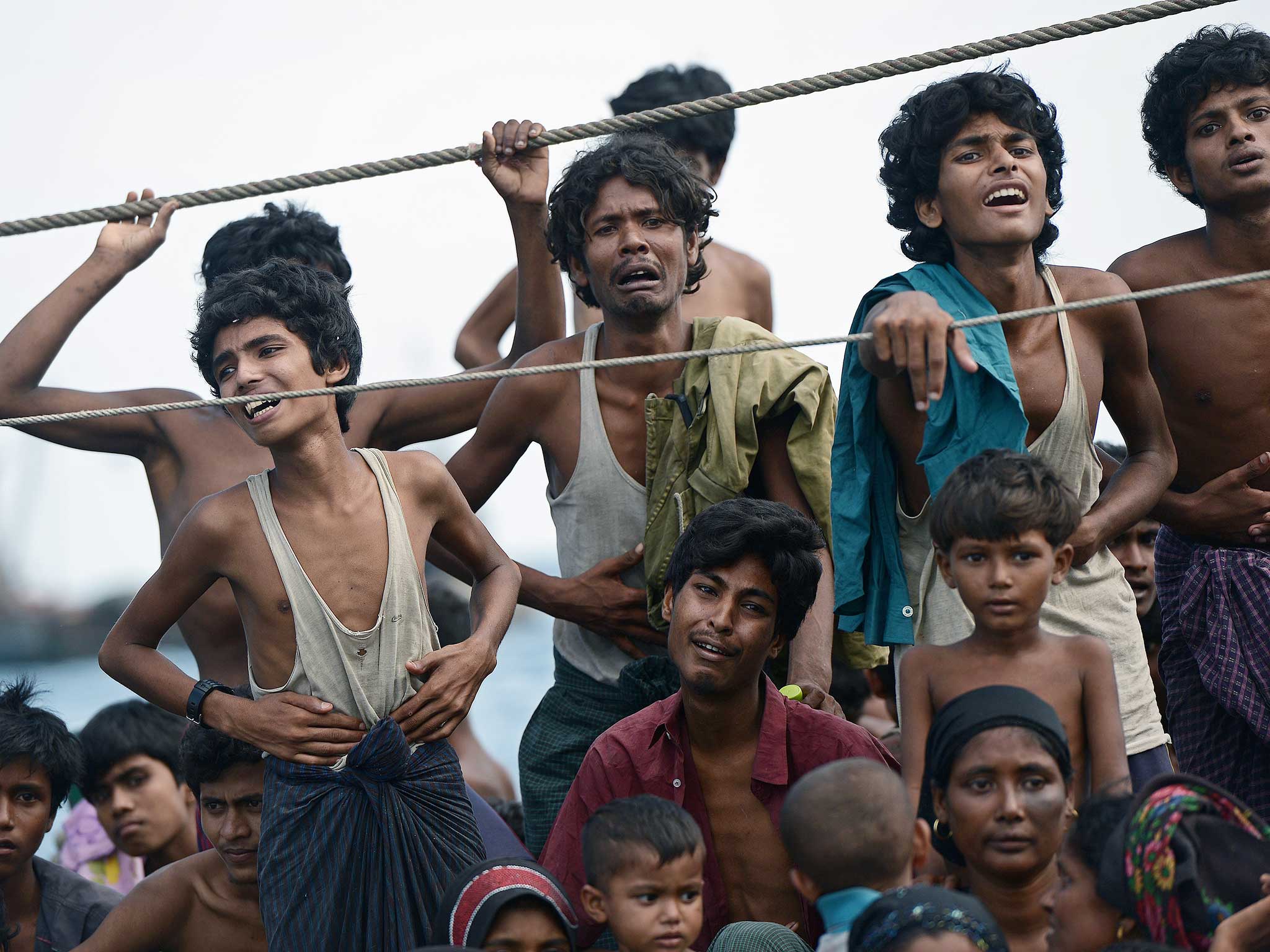Rohingya migrants stand and sit on a boat drifting in Thai waters off the southern island of Koh Lipe in the Andaman sea on 2015