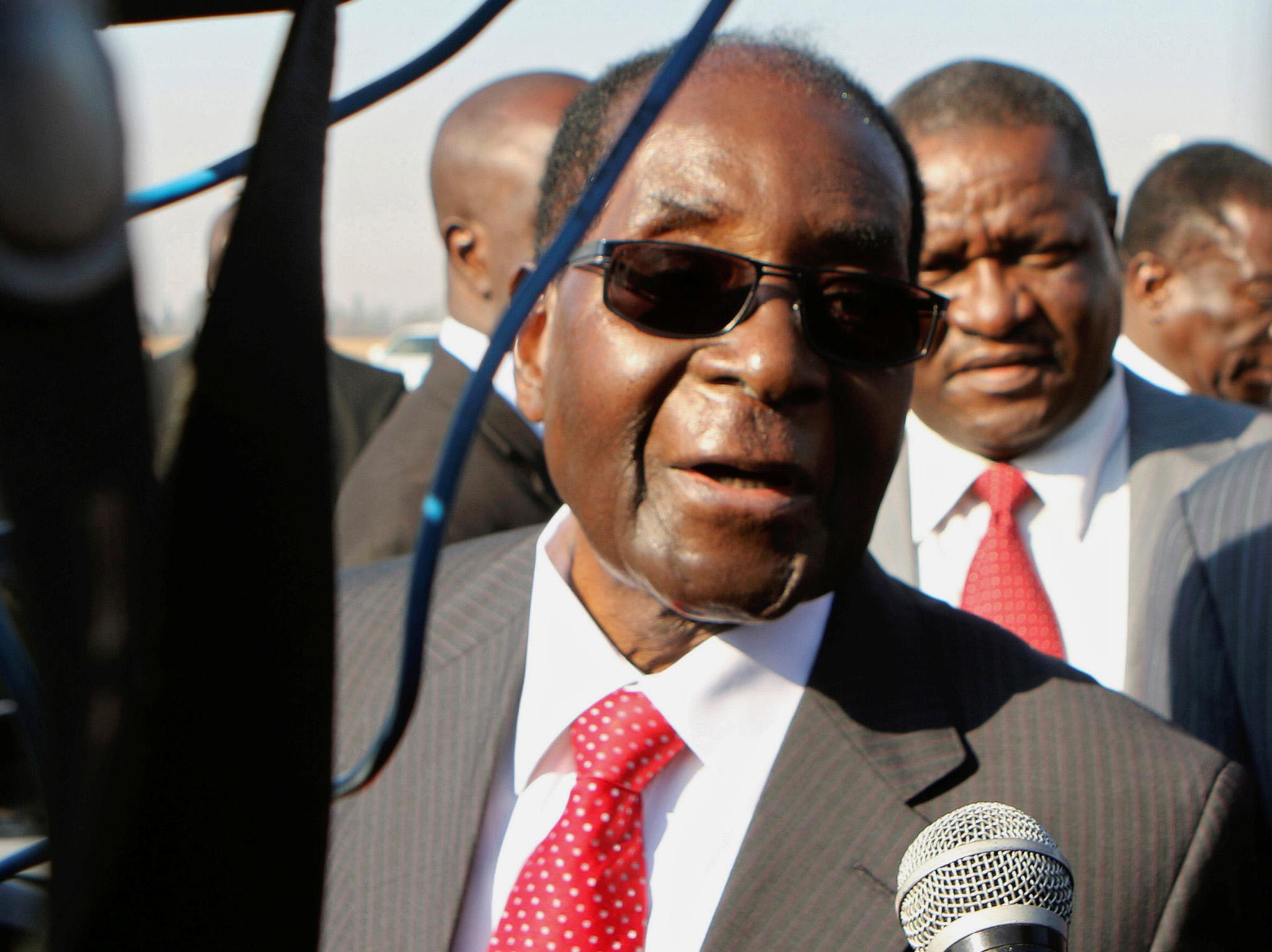 The Zimbabwean dictator talks to reporters after arriving at Harare airport on Saturday