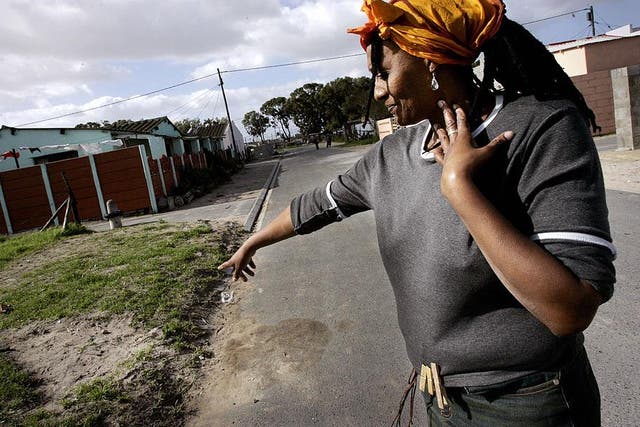 Nyanga resident Pam Mokoena points out the spot where her brother was gunned down outside her house in the Nyanga township, on the outskirts of Cape Town
