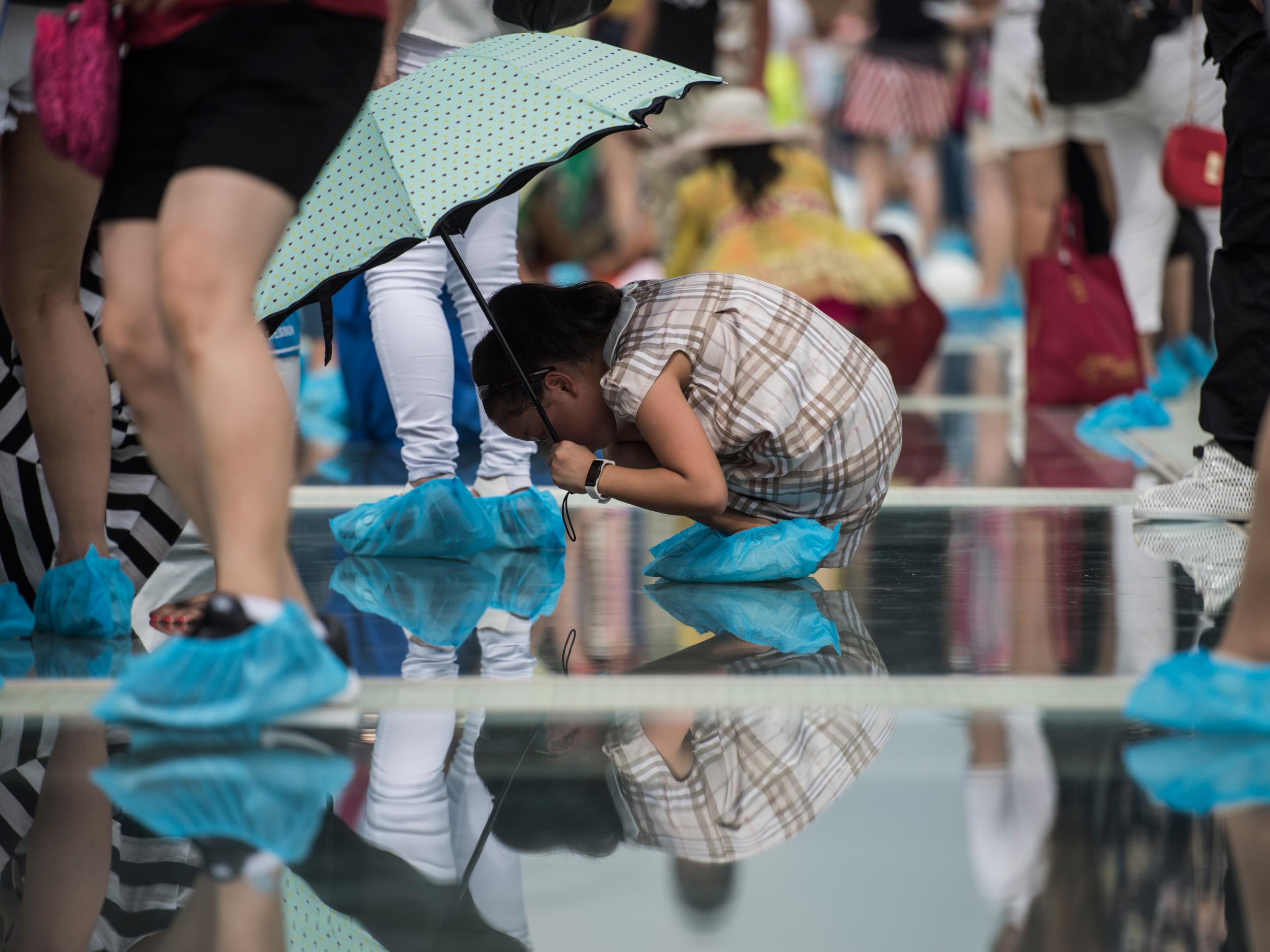 A girl looks through the glass on the world's highest and longest glass-bottomed bridge