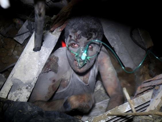 A Palestinian child is rescued from under the wreckage of their house, destroyed by an Israeli airstrike during Operation Protective Edge in July 2014 