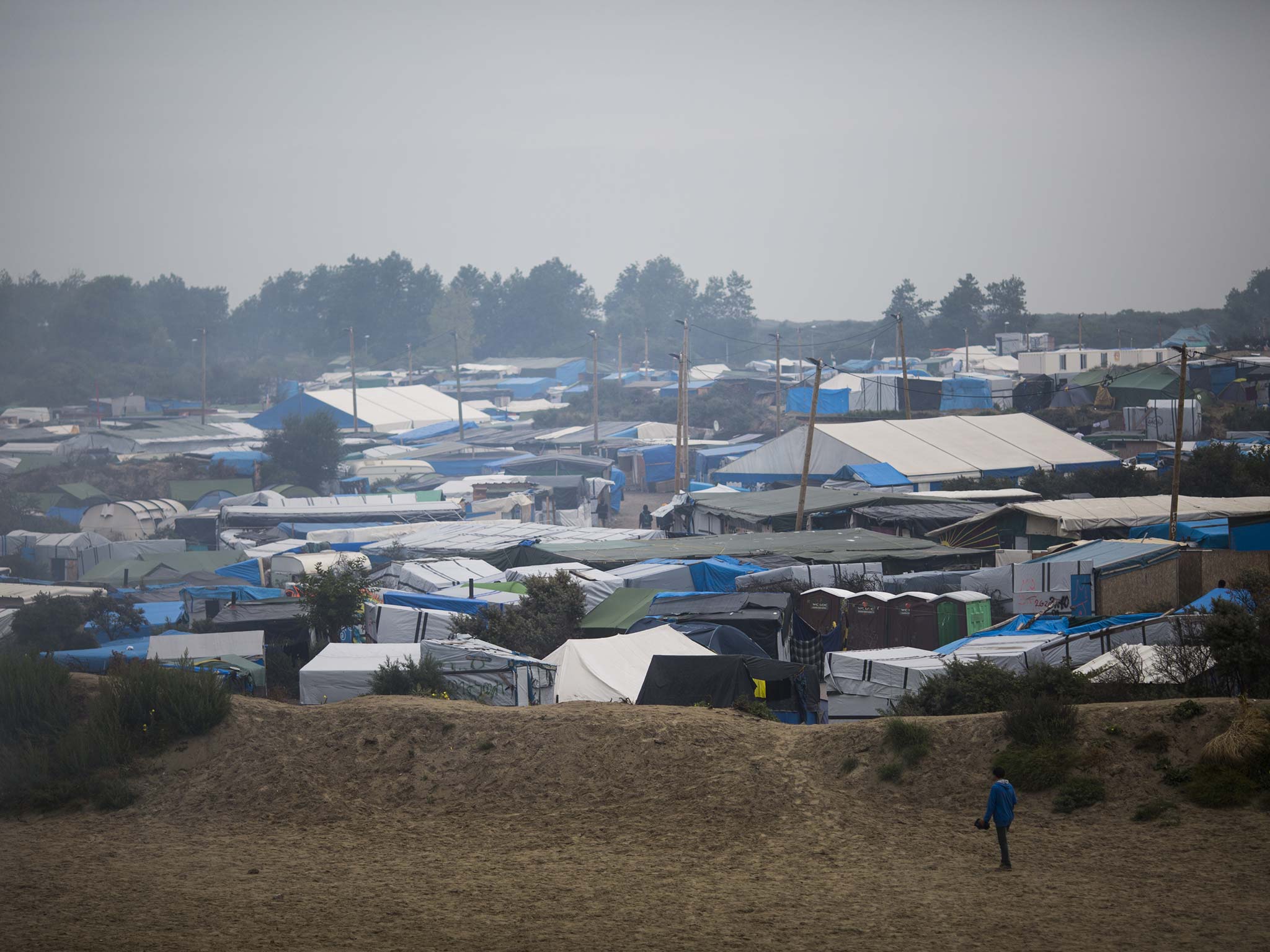Despite the clearing of the Calais ‘jungle’, pictured, migrants have remained in the area