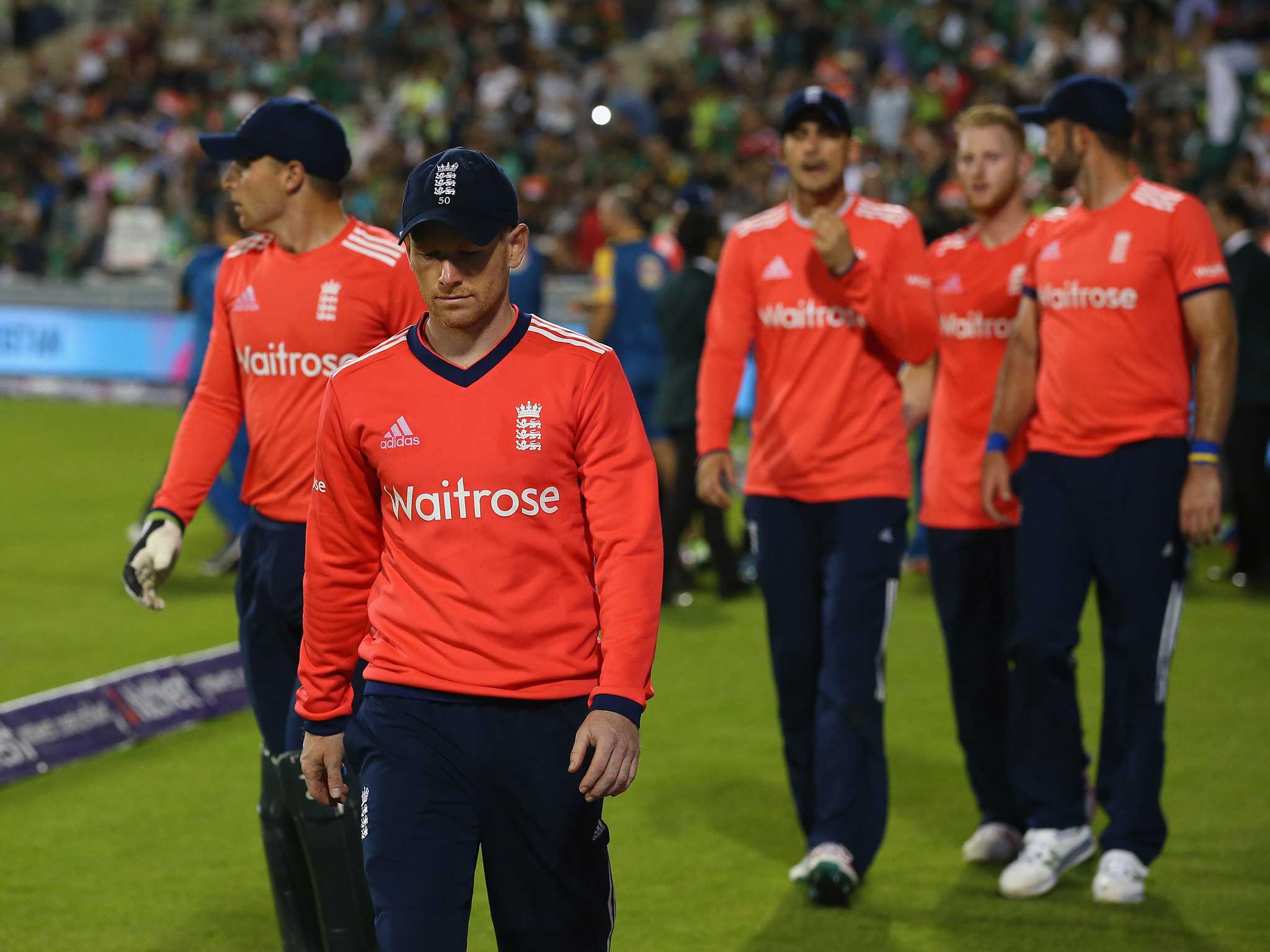 Eoin Morgan and his defeated England team-mates trudge off the field