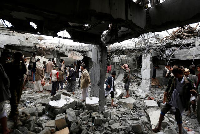 <p>People gather at a building destroyed by Saudi-led air strikes in the northwestern city of Amran, Yemen</p>