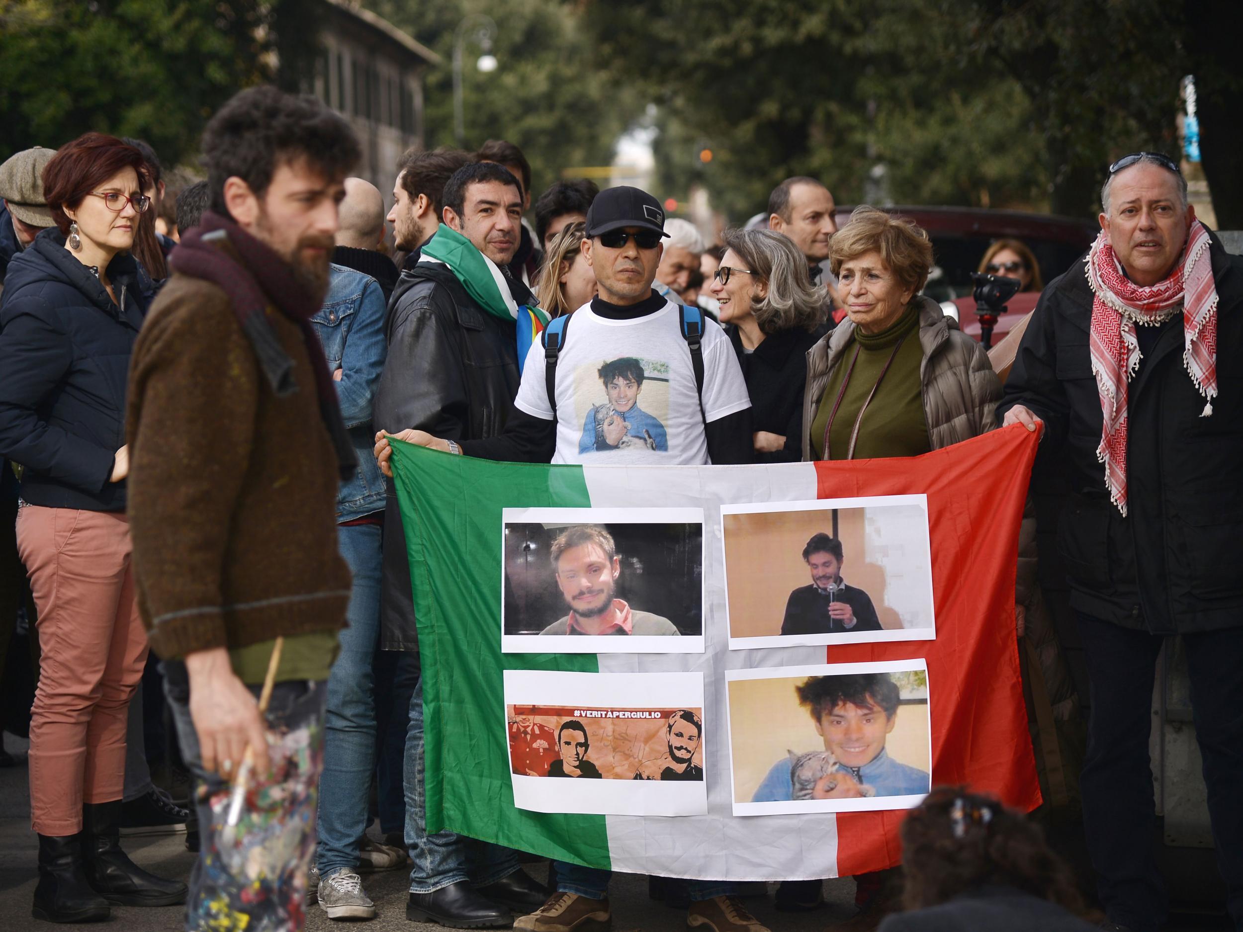 People hold an Italian flag with photos of Giulio Regeni during a demonstration in front of the Egypt's embassy in Rome on 25 February