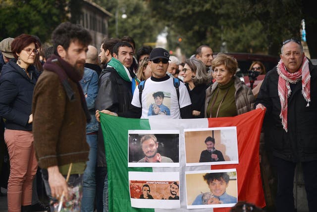 People hold an Italian flag with photos of Giulio Regeni during a demonstration in front of the Egypt's embassy in Rome on 25 February