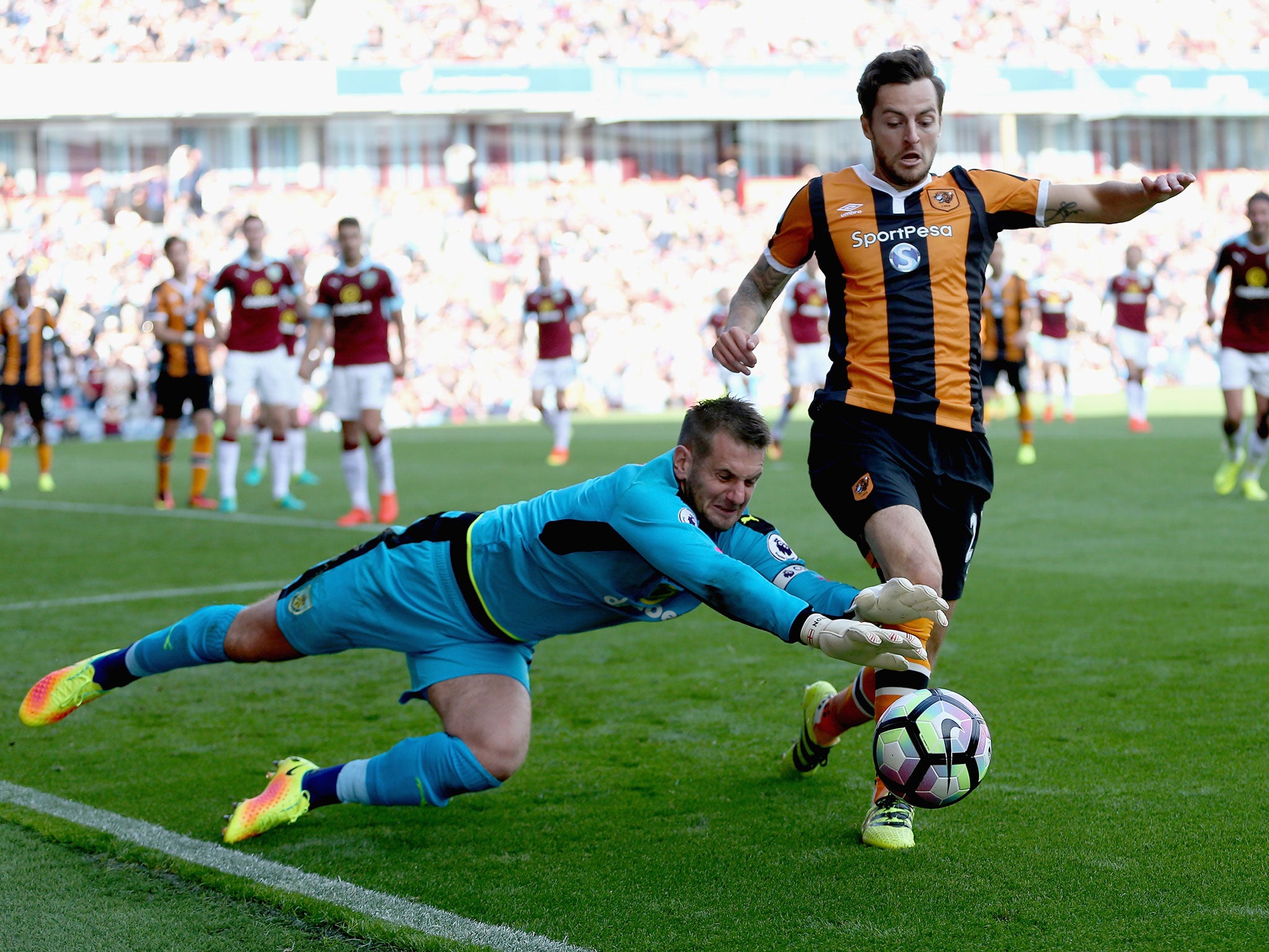 Burnley's Thomas Heaton dives for the ball under pressure from Hull's Ryan Mason