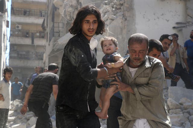  A Syrian civil defence member and a volunteer carry a little girl rescued from under the rubble of destroyed buildings following a reported airstrike on the rebel-held Salihin neighbourhood of the northern city of Aleppo, on September 10, 2016