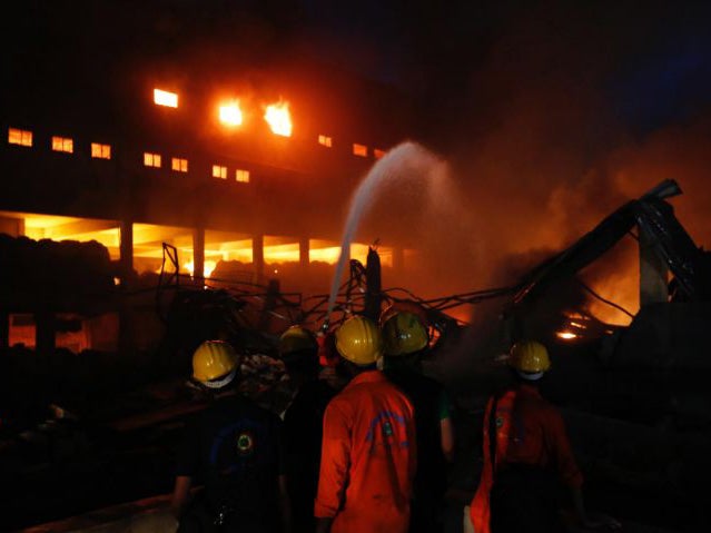 Firefighters work to put out a fire at a packaging factory in Tongi