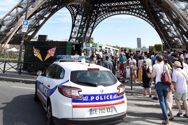 Police officers patrol around the Eiffel tower in Paris