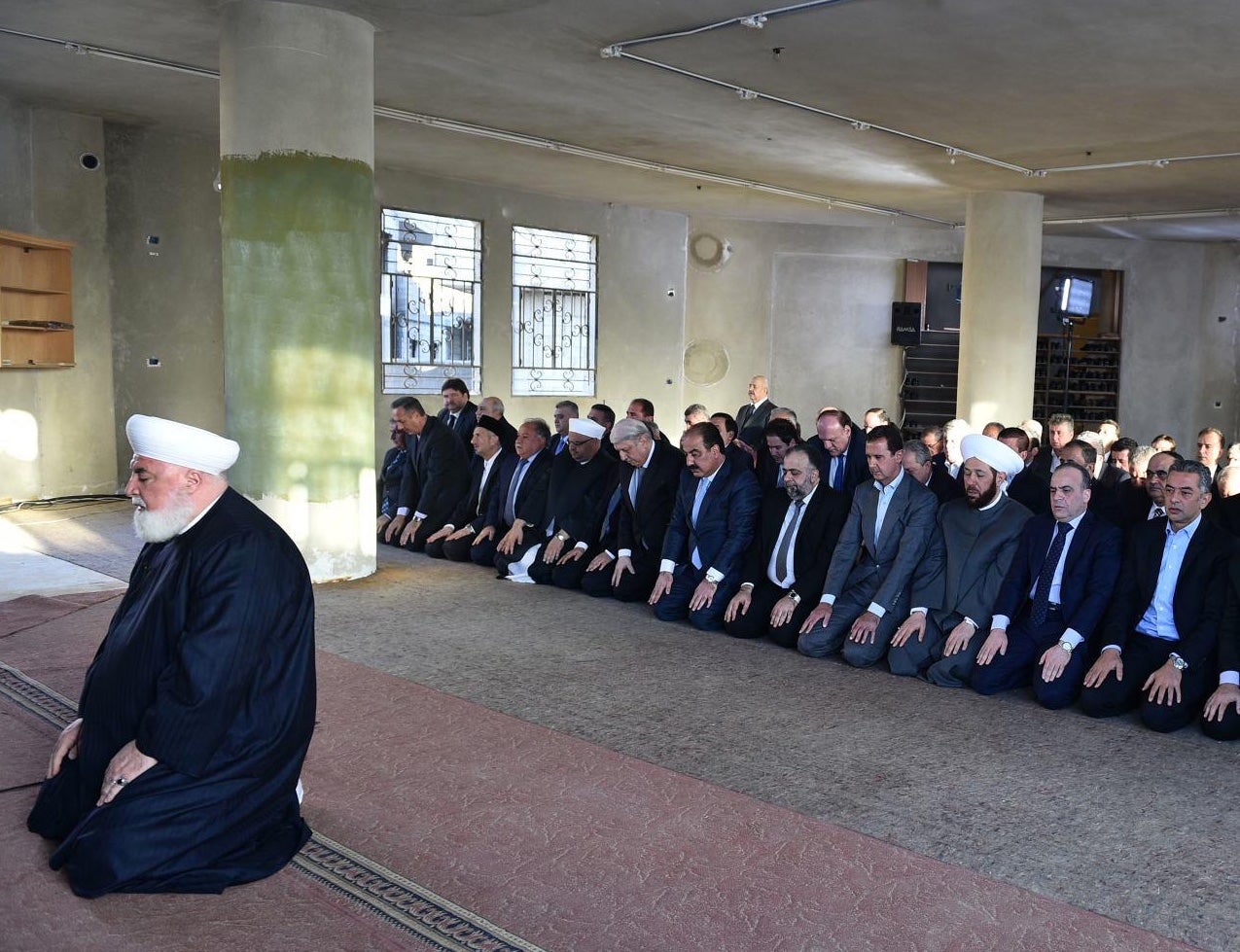 Assad is pictured praying at a mosque in Daraya, Damascus, 12 September 2016