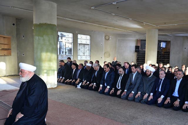 Assad is pictured praying at a mosque in Daraya, Damascus, 12 September 2016